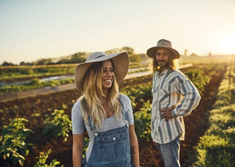Two farmers smiling in field