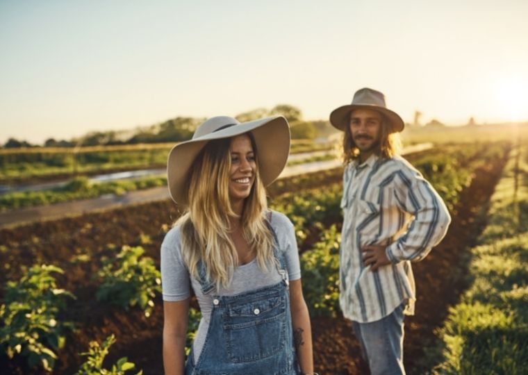 Two farmers smiling in fiel