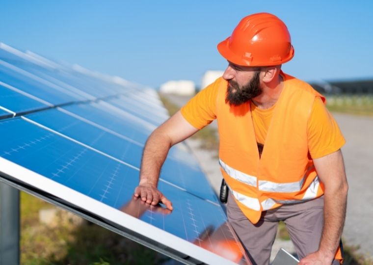 worker checking solar panels 